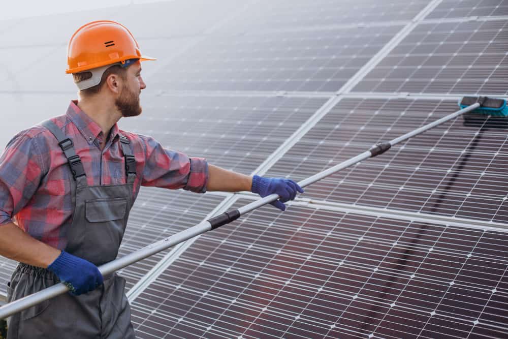 un homme en train de faire un nettoyage toiture photovoltaique
