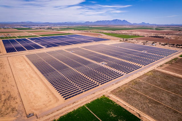 un champ de panneaux solaires entouré de champs