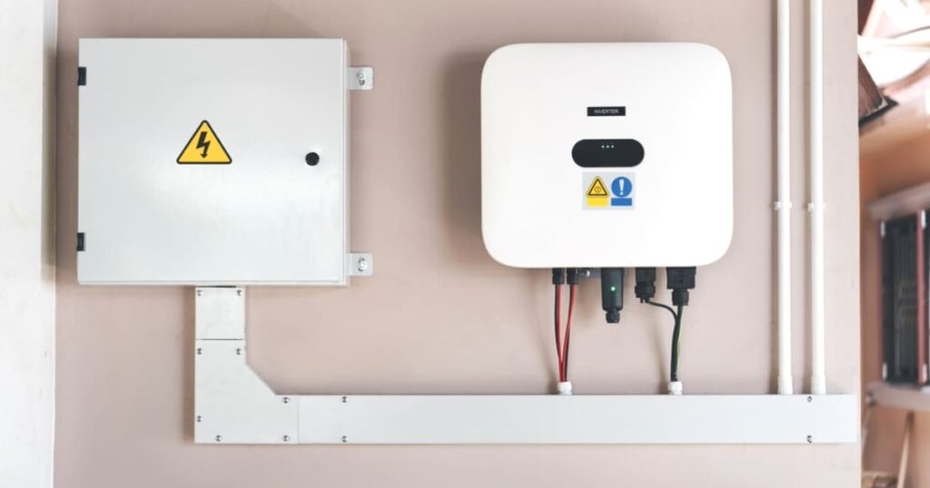 un onduleur solaire photovoltaïque fixé sur un mur rose