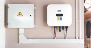 un onduleur solaire photovoltaïque fixé sur un mur rose