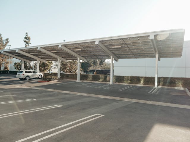un suv blanc sous une ombrière photovoltaique, ombrière photovoltaïque obligation