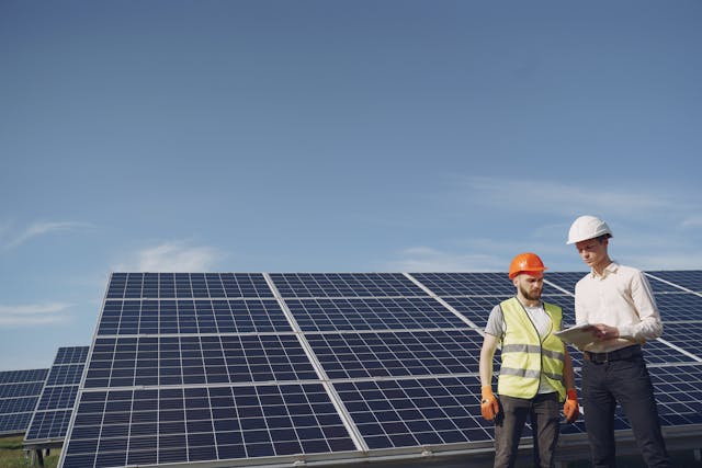 deux professionnels qui discutent devant un champs de panneaux solaires, PPA solaire