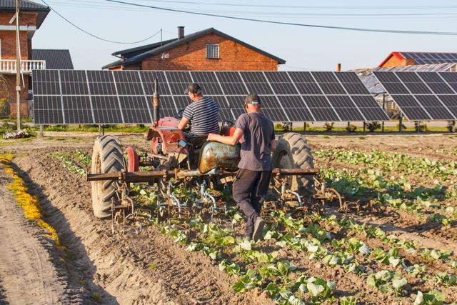 deux agriculteurs sur un tracteurs dans un champs, avec une Installation agrivoltaïque devant