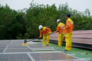 des professionnels qui nettoient des panneaux solaires, Maintenance photovoltaïque