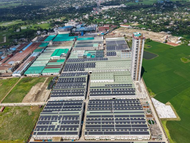 des bâtiment industriel photovoltaïque entourés d'espaces verts vus d'en haut, bâtiment industriel photovoltaïque